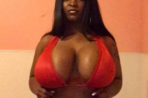 Femme noire en maillot rouge avec forte poitrine